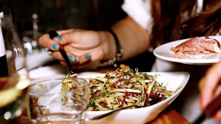 Woman serving herself salad and meat